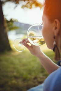 Woman drinking wine green grass sunny day